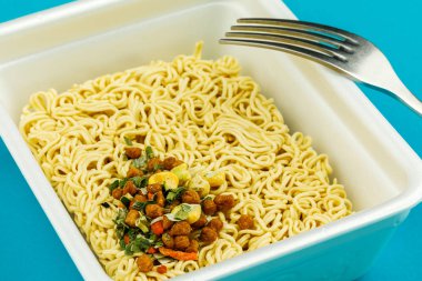 Mavi arka planda bir tabak erişte. Üst görünüm.