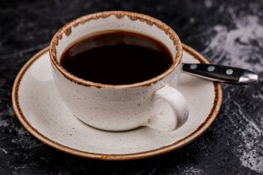 Beton bir masada bir fincan kahve.