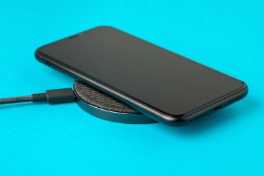 Akıllı telefon kablosuz şarj cihazıyla şarj edilir. 