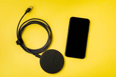 Akıllı telefon kablosuz şarj cihazıyla şarj edilir. 