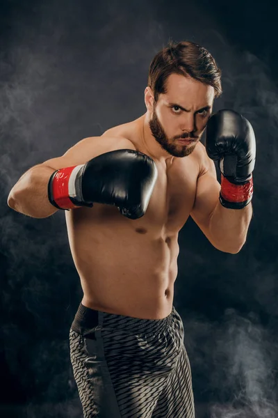 Boxeador sin camisa con guantes sobre fondo oscuro en humo — Foto de Stock