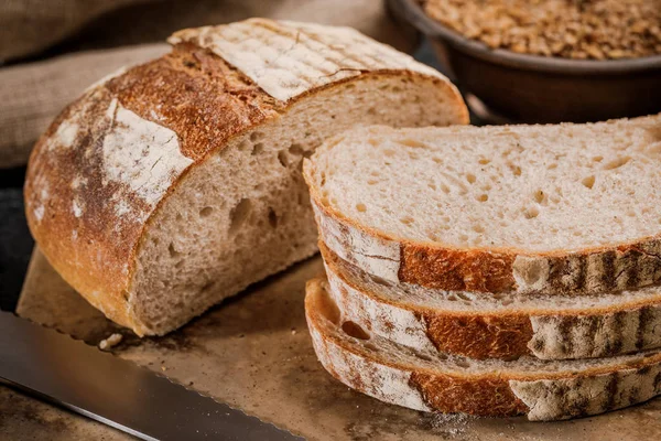 Świeżo upieczony chleb pokrojony na kawałki na drewnianej desce — Zdjęcie stockowe