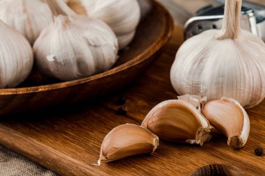 Çuval bezi üzerinde ahşap tabakta sarımsak karanfilleri
