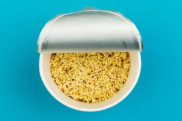 A plate of noodles on a blue background. Top view. — Stock Photo, Image