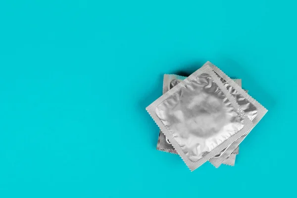 Preservativo sobre fundo azul. O conceito de sexo seguro. — Fotografia de Stock