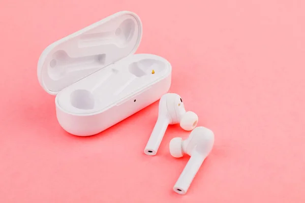Pár bílých sluchátek na růžovém pozadí — Stock fotografie