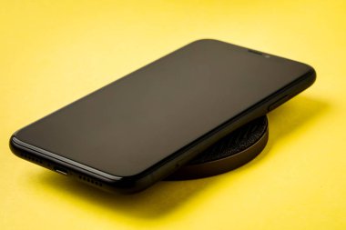 Akıllı telefon kablosuz şarj cihazıyla şarj edilir. 
