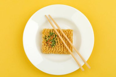 Sarı bir arka plan üzerinde bir tabak erişte. Üstte görüntü.