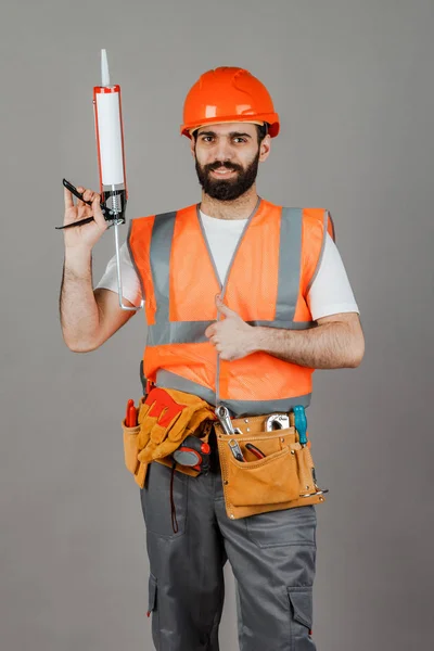 Middle-aged male builder in uniform on grey background — Stock Photo, Image