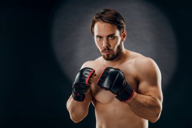 Boks eldivenli bir adam. Siyah arka planda boks yapan bir adam. Sağlıklı yaşam tarzı kavramı.