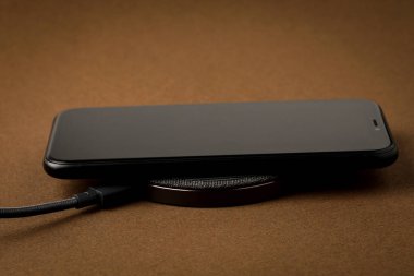 Akıllı telefon kablosuz şarj cihazı ile şarj edilir. Yeni teknolojiler kavramı