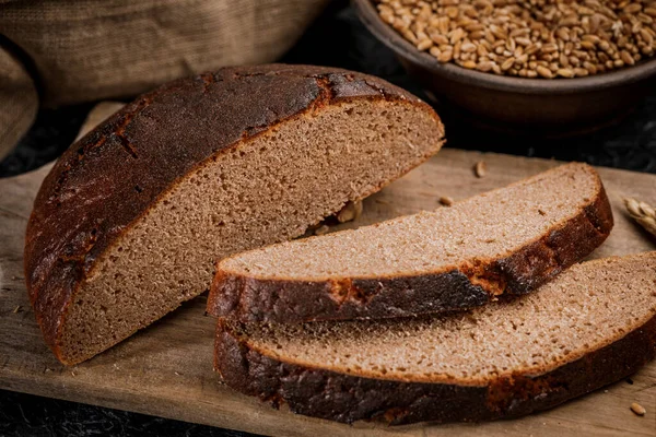 Świeżo Upieczony Chleb Pokrojony Kawałki Drewnianej Desce — Zdjęcie stockowe