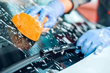 Bir adam bir sabun beyaz araba yıkar. Temizlik kavramı.