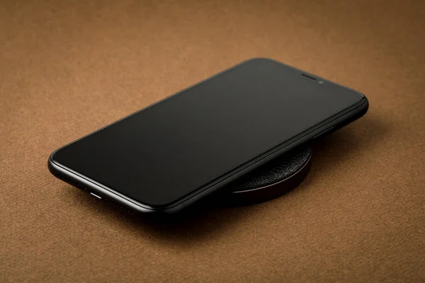 The smartphone is charged by a wireless charger  Concept of new technologies