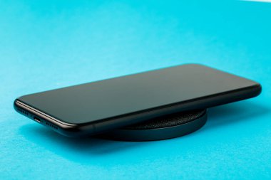 Akıllı telefon kablosuz şarj cihazı ile şarj edilir. Yeni teknolojiler kavramı