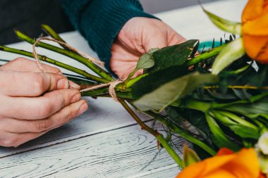 İşteki çiçekçi farklı çiçeklerden modern bir buket yapıyor.