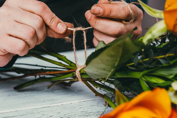 Florist at work makes a fashionable modern bouquet of different flowers