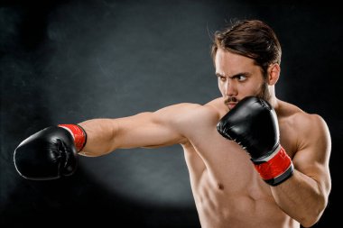 Boks eldivenli bir adam. Siyah arka planda boks yapan bir adam. Sağlıklı yaşam tarzı kavramı.