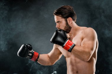 Boks eldivenli bir adam. Siyah arka planda boks yapan bir adam. Sağlıklı yaşam tarzı kavramı.