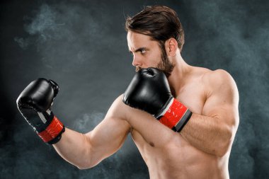 Boks eldivenli bir adam. Siyah arka planda boks yapan bir adam. Sağlıklı yaşam tarzı kavramı.