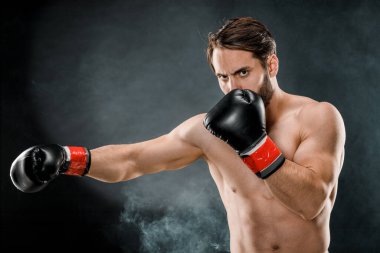 Boks eldivenli bir adam. Siyah arka planda boks yapan bir adam. Sağlıklı yaşam tarzı kavramı.