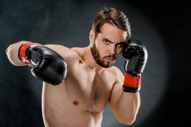 Boks eldivenli bir adam. Siyah arka planda boks yapan bir adam. Sağlıklı yaşam tarzı kavramı.