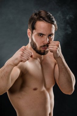 Boksör, kameraya öfkeyle bakan bir dövüşçü. Siyah arka planda izole edilmiş beyaz erkek fitness modeli.