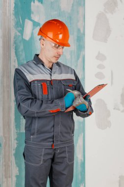 Bir adam inşaat alanında çalışan bir mühendis, mimar ve müfettiştir. Konut inşaatı projelerini izlemek, planlamak ve denetlemek için çalışır..