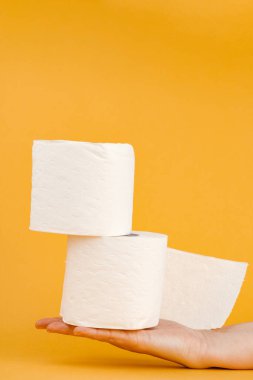 Sarı arka planda bir kadının elinde tuvalet kağıdı rulosu..