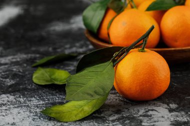 Mermer zemin üzerinde mandalinalar olan bir tabak..