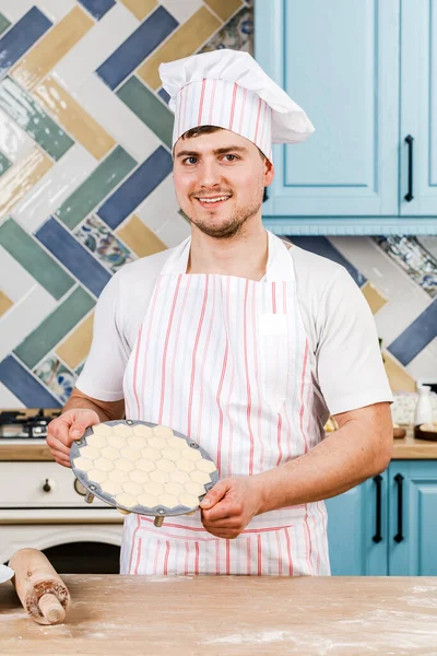 台所のコックは彼の手に餃子を保持し 彼の手でそれらを指す 料理の概念 — ストック写真
