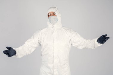 Tek kullanımlık anti-bakteriyel izolasyon giysisi içindeki bir insan epidemiyoloğu beyaz arka planda el hareketlerini gösteriyor. Salgın ve tıbbi konsept.