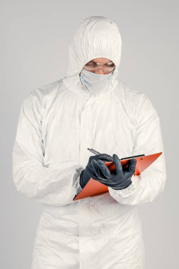 Doktor B formları doldurur. Üniformalı ve maske takan bir adam sonuçları kaydeder. Sağlık ve İlaç kavramı.