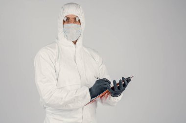 Doktor B formları doldurur. Üniformalı ve maske takan bir adam sonuçları kaydeder. Sağlık ve İlaç kavramı.