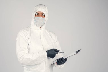 Doktor B formları doldurur. Üniformalı ve maske takan bir adam sonuçları kaydeder. Sağlık ve İlaç kavramı.