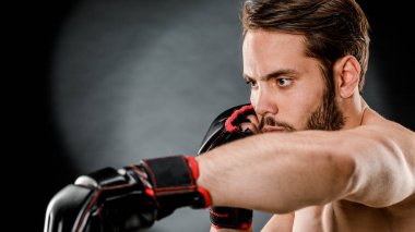 Boks eldivenli bir adam. Siyah arka planda boks yapan bir adam. Sağlıklı yaşam tarzı kavramı.