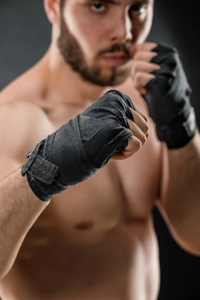 Close-up of a male boxer\'s hand with Boxing bandages. Fists of a fighter before a fight or training in the gym. The concept of sport