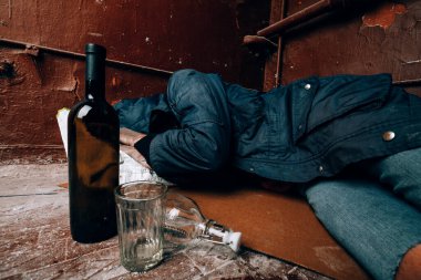 Evsiz bir adam, bir sarhoş, sokakta uyuyakaldı. Alkolizm ve evsizlik kavramı.