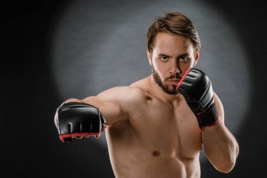 Boks eldivenli bir adam. Siyah arka planda boks yapan bir adam. Sağlıklı yaşam tarzı kavramı.