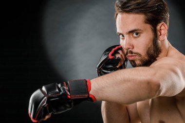 Boks eldivenli bir adam. Siyah arka planda boks yapan bir adam. Sağlıklı yaşam tarzı kavramı.