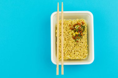 Mavi arka planda bir tabak erişte. Üst görünüm