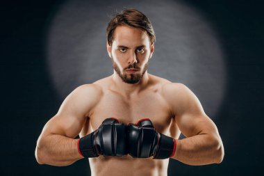 Boks eldivenli bir adam. Siyah arka planda boks yapan bir adam. Sağlıklı yaşam tarzı kavramı.