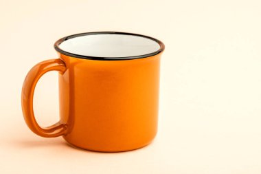 Sarı arka planda boş bir demir bardak..