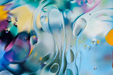 Su yüzeyindeki yağ damlacıklarının hareketine yakın çekim. Su yüzeyindeki yağ damlalarının renkli ve soyut makro arkaplanı