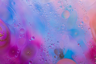 Su yüzeyindeki yağ damlacıklarının hareketine yakın çekim. Su yüzeyindeki yağ damlalarının renkli ve soyut makro arkaplanı