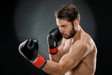 Boks eldivenli bir adam. Siyah arka planda boks yapan bir adam. Sağlıklı yaşam tarzı kavramı.