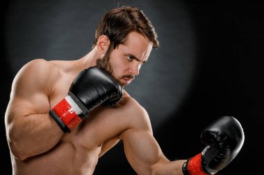 Boks eldivenli bir adam. Siyah arka planda boks yapan bir adam. Sağlıklı yaşam tarzı kavramı.