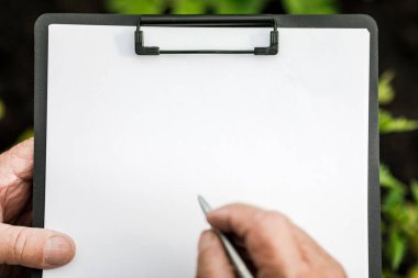 Çiftçinin ellerine yakın çekim. Çiftçi gözlemleri bir tablete kaydeder. Tarım ve mahsul üretimi kavramı