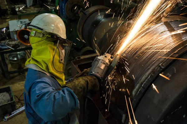 Працівник металу шліфувальної машини ремонт зварювальний апарат на сталевому рулоні Стокове Фото