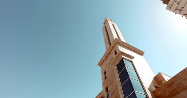 Высокий минарет на фоне голубого неба . — стоковое видео